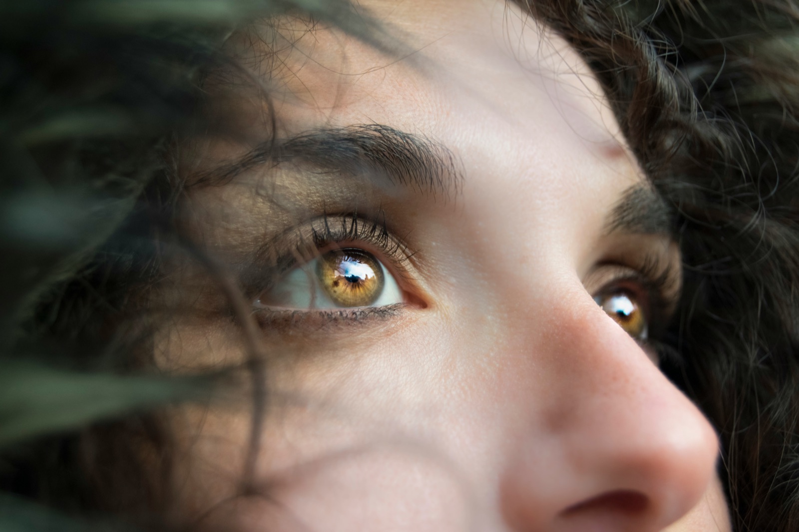 Close-up of a person's hazel eyes looking upward